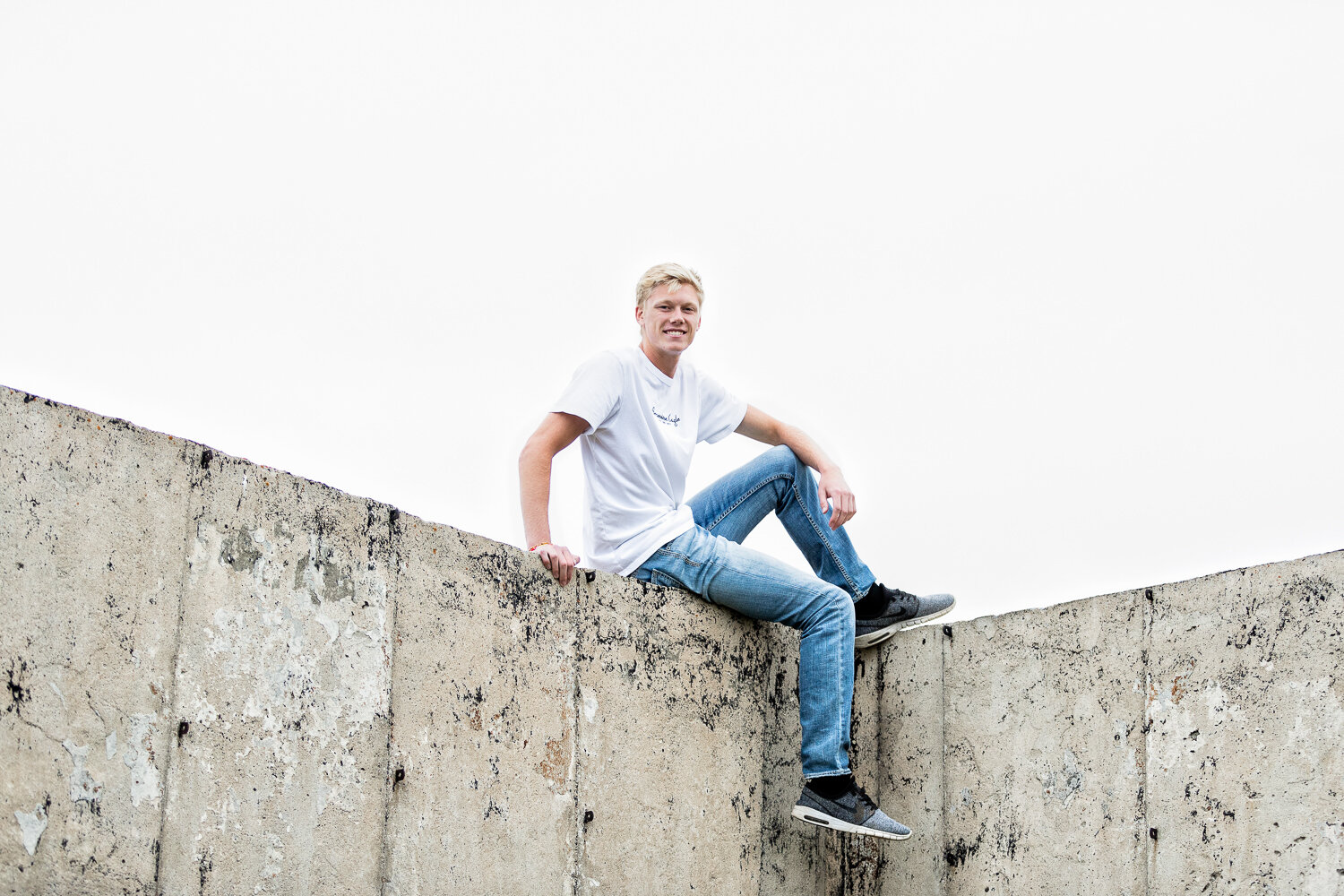 Senior boy sitting on concrete wall