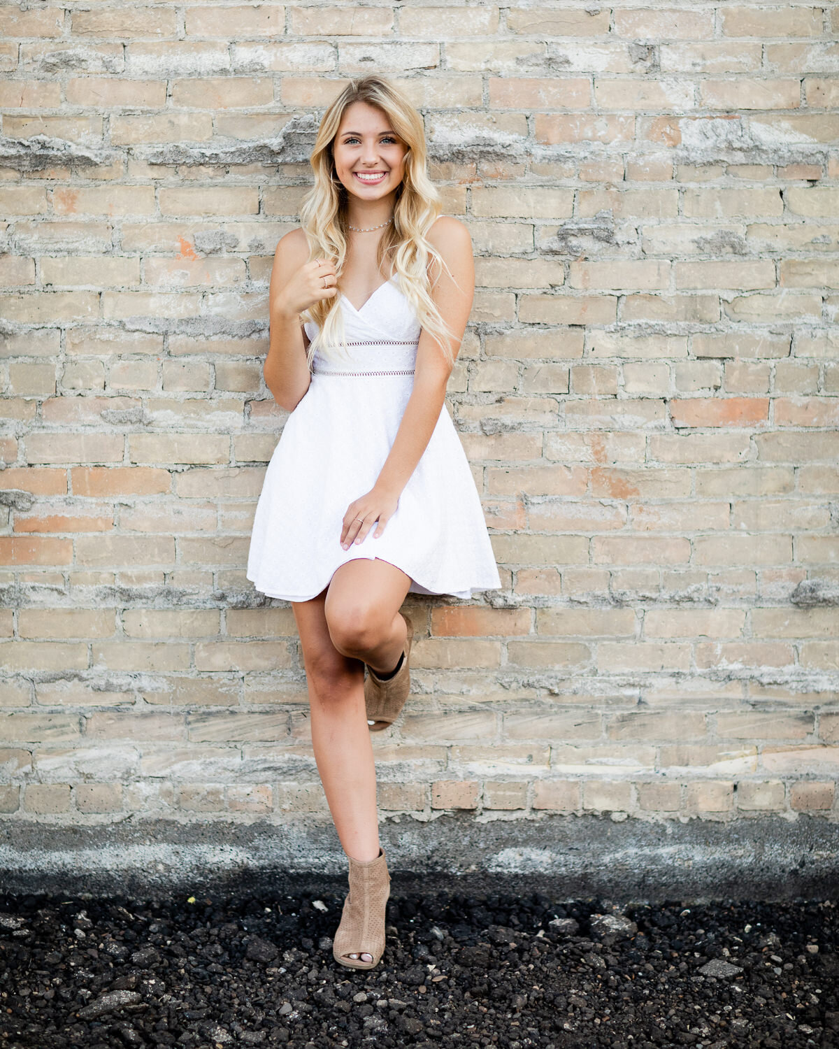 White dress against brick wall