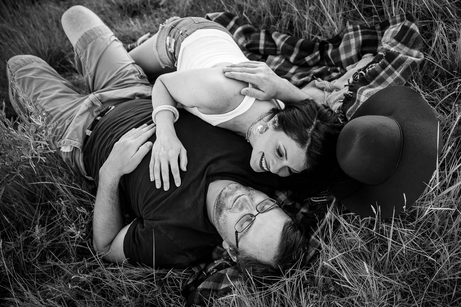 black and white of couple laying on the ground 