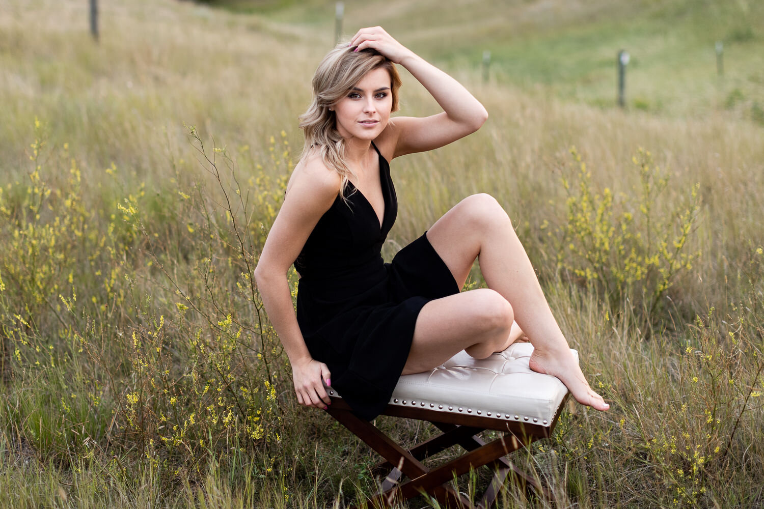 Black sundress on a bench in tall grass