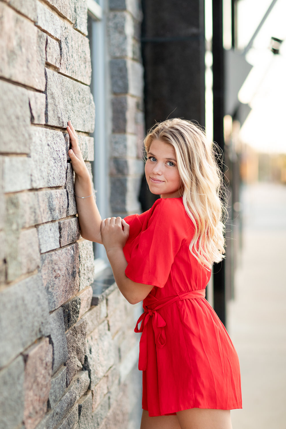 Senior girl by brick wall