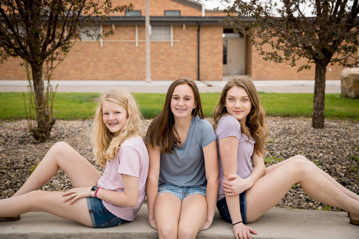 3 teen girls posed on a bench 