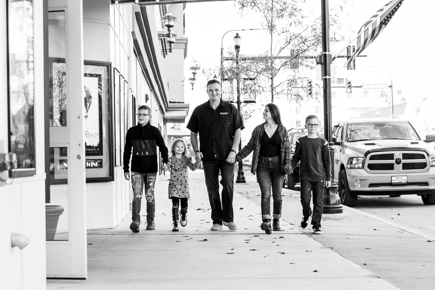 black and white of family walking in front of the theatre
