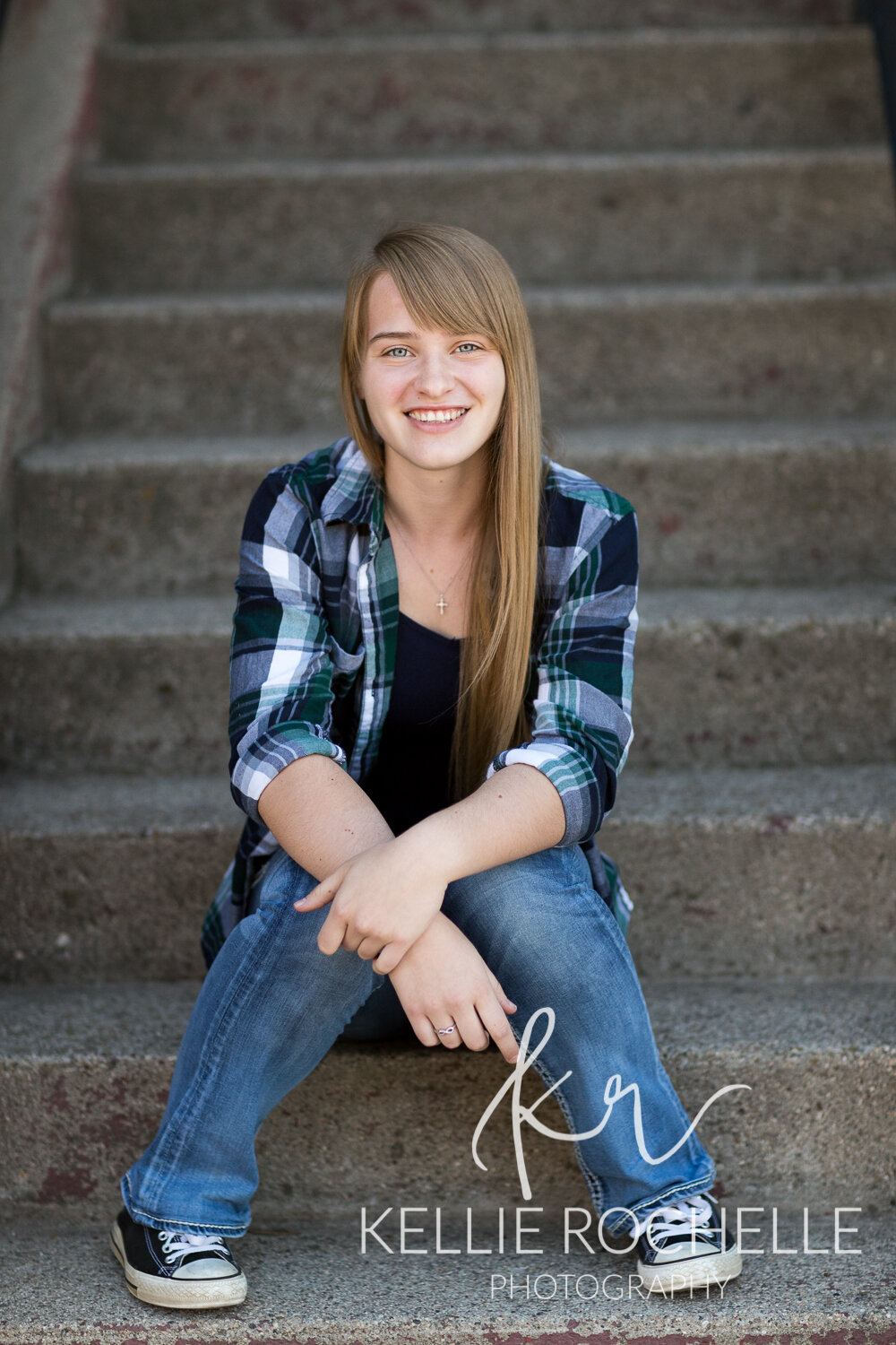 Senior girl sitting on steps in flannel