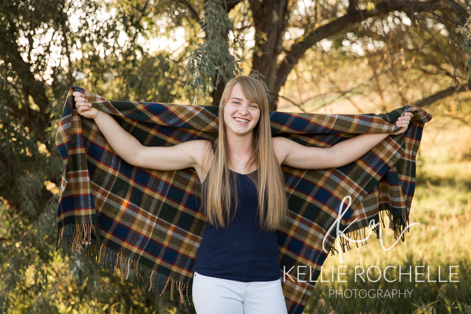 Senior girl posing with plaid blanket 