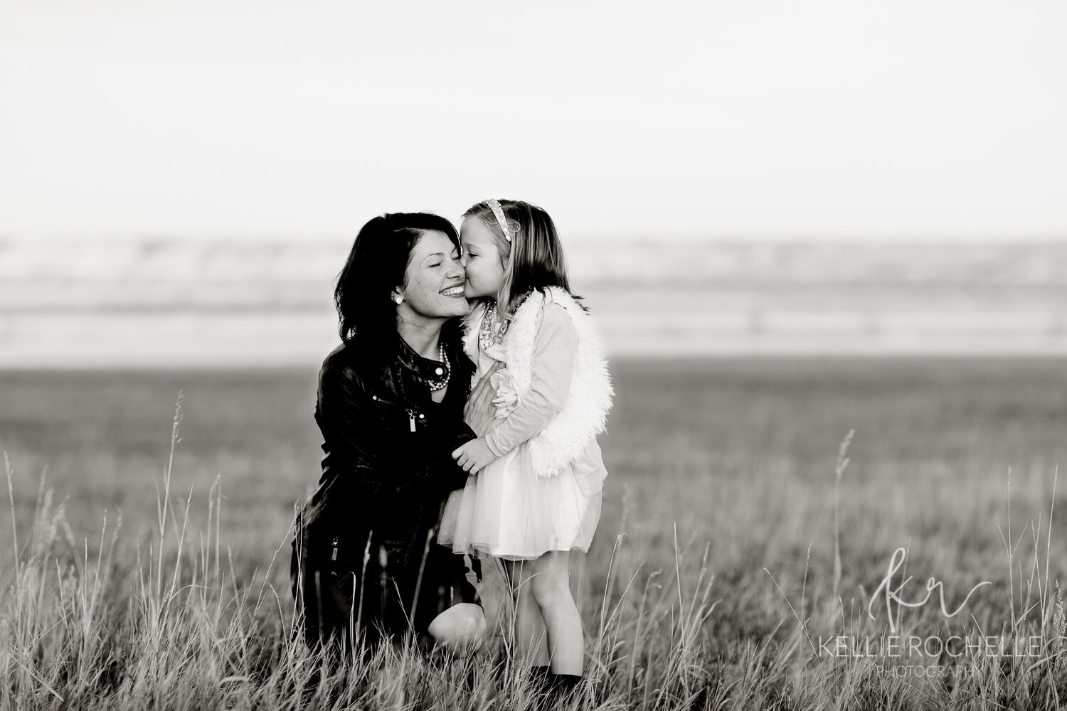 black and white of mom and daughter whispering