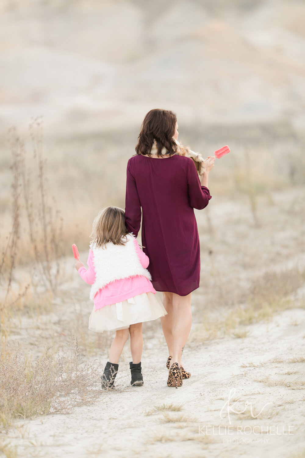mom and daughter walking eating popsicles