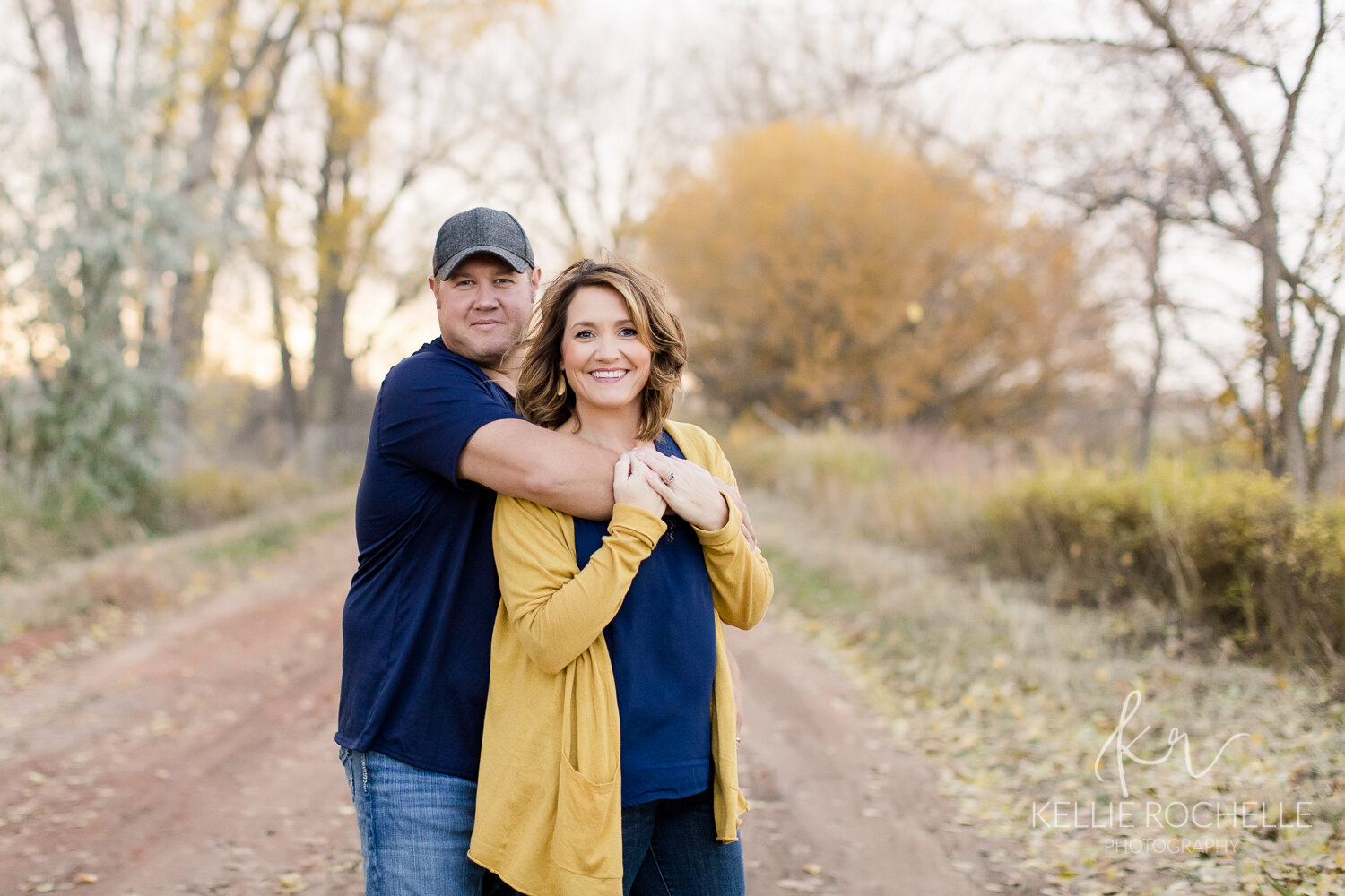couple in prom pose in fall tree row