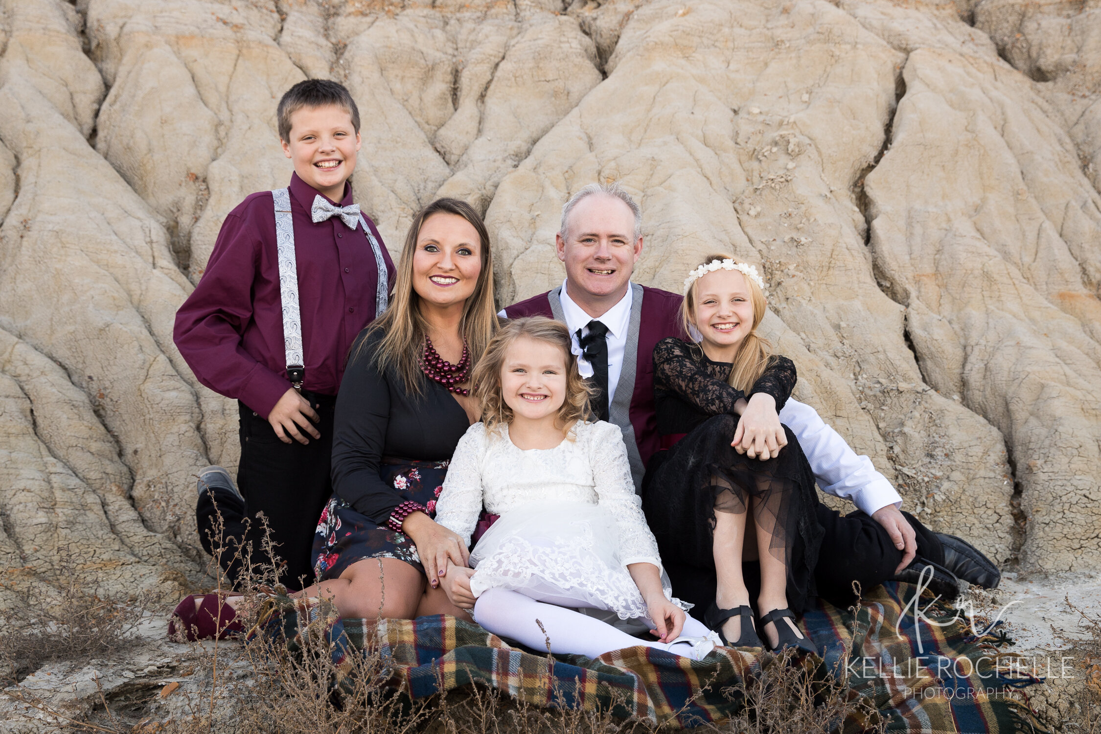 Family sitting on blanket maroon colors