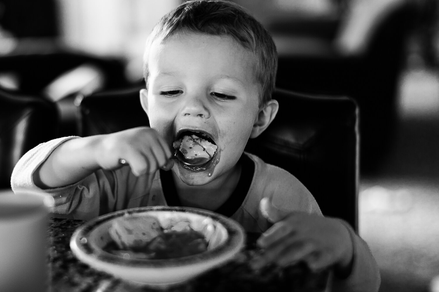 black and white little boy eating soup- Williston documentary photographer
