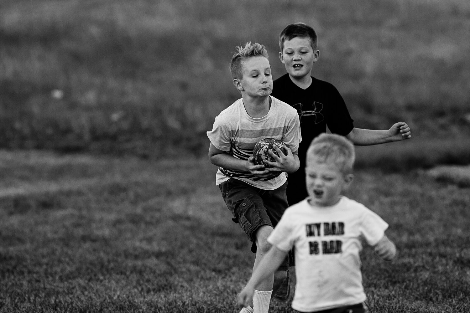 boys playing football black and white photo - Williston children photographer