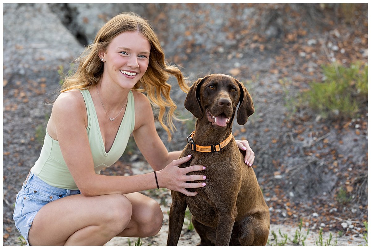 A North Dakota teen poses with her dog during a senior session with Kellie Rochelle Photography at Lewis and Clark State Park.