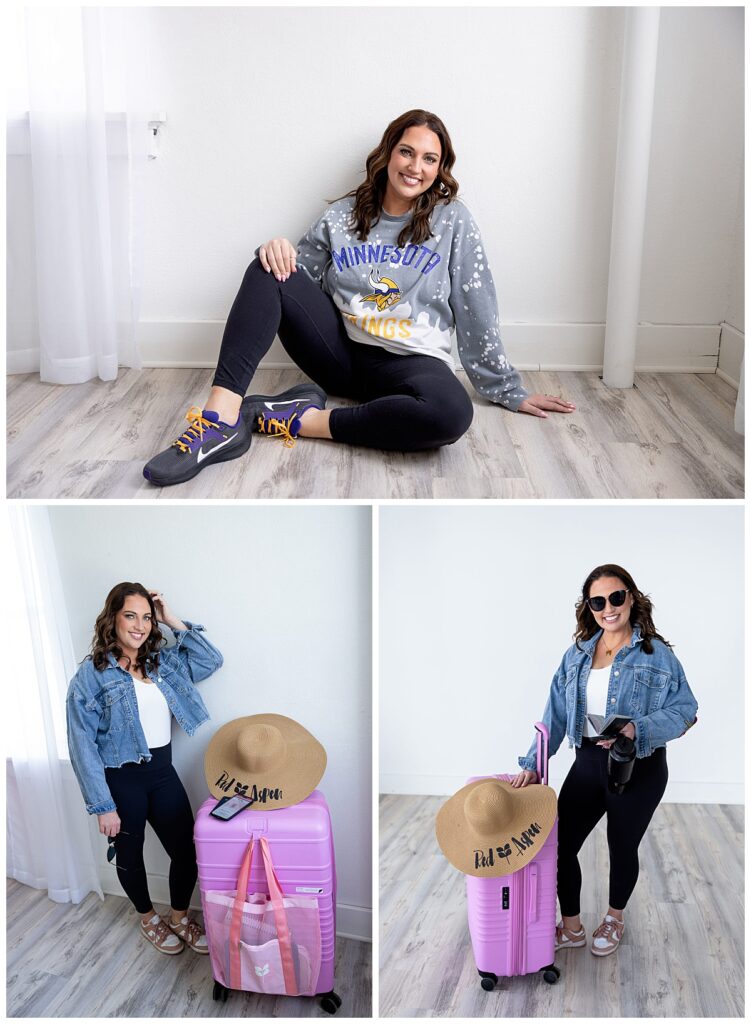 A woman with dark hair stands next to a Red Aspen sun hat propped atop pink luggage while wearing a jean jacket with black leggings for her branding photoshoot with Kellie Rochelle Photography.