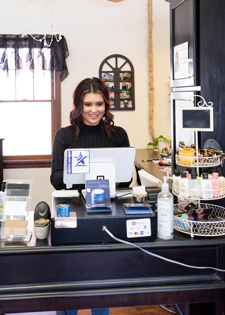 Creative Elements salon owner, Shandi, stands before her Square POS system during a brand photography shoot with Kellie Rochelle Photography.