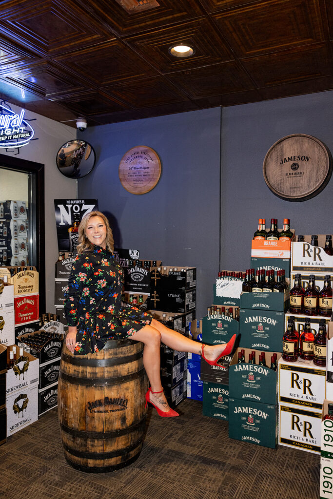 Sheila Goehring sits atop of a Jack Daniel's whiskey barrel in her Williston, ND liquor store, 26th Street Liquor, during a branding session with Kellie Rochelle Photography, a North Dakota based brand photographer. 