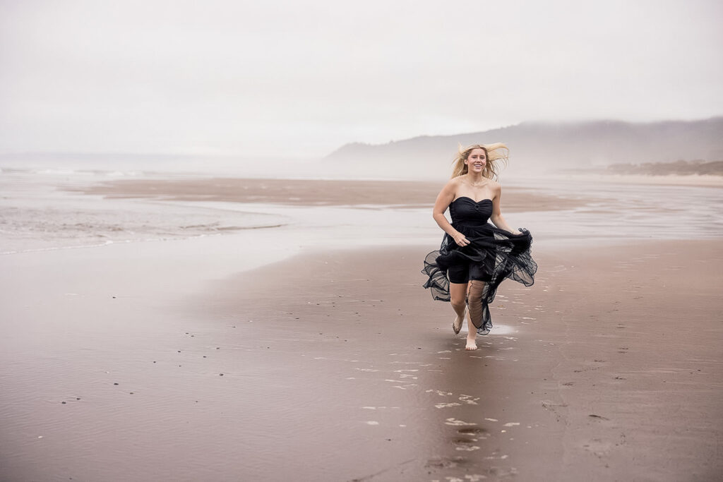 Kaitlyn standing on the misty shores of Twin Rocks Beach at sunrise.