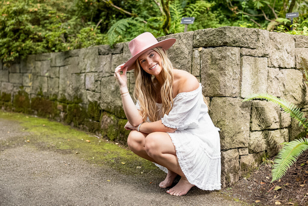 Kaitlyn at Crystal Springs Rhododendron Garden, surrounded by lush greenery during her senior photography session.