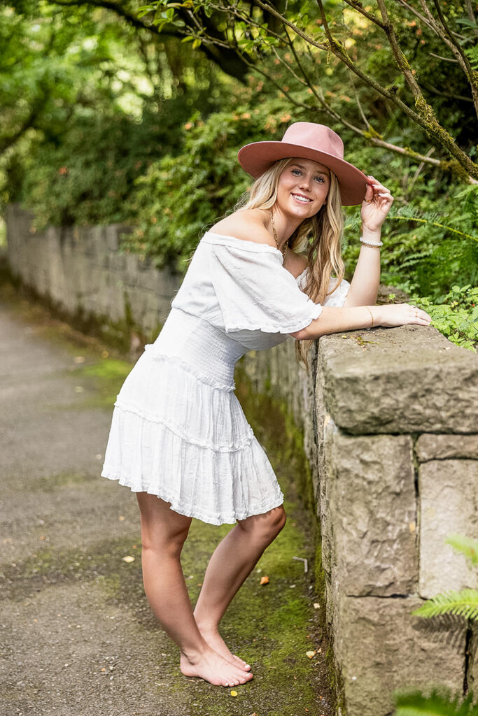 Kaitlyn at Crystal Springs Rhododendron Garden, surrounded by lush greenery during her senior photography session.