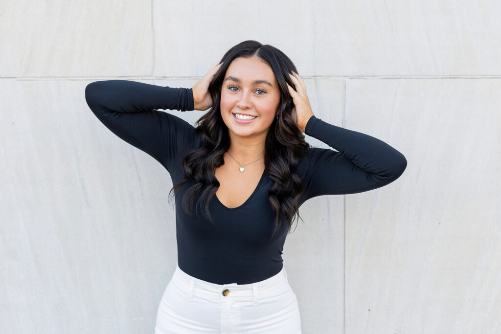 Senior pictures in downtown North Dakota, featuring Jayla in a black bodysuit and white jeans for an urban look.
