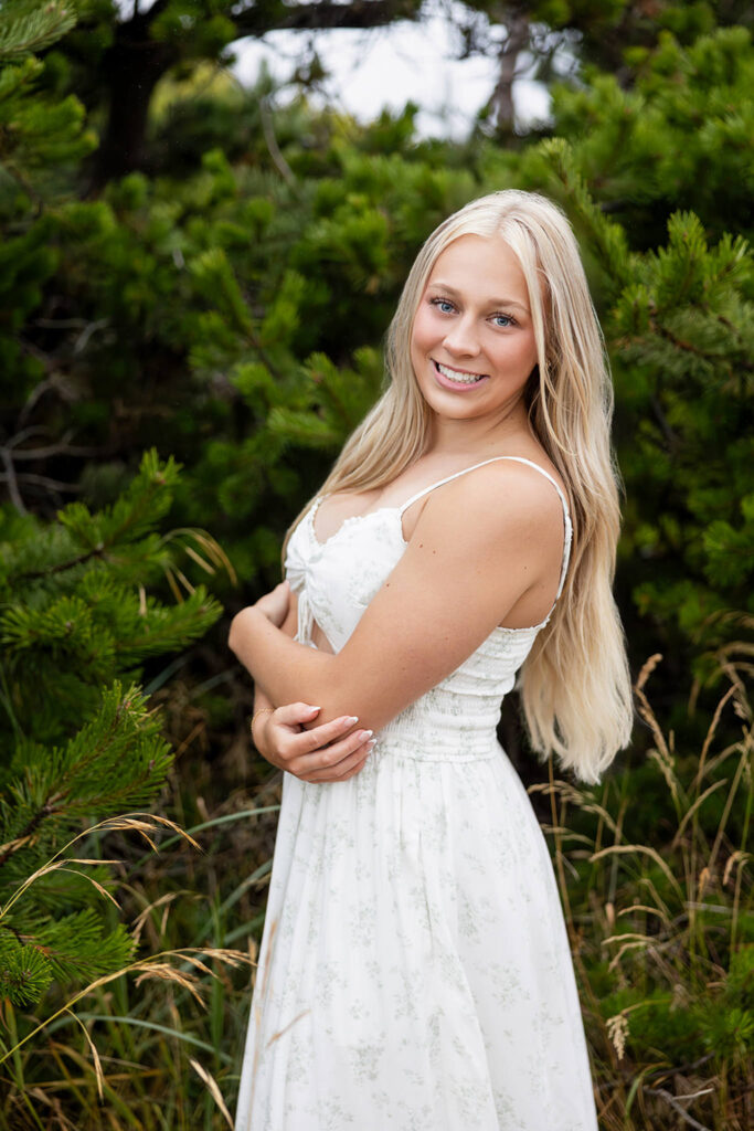 Kiera in a floral dress at Crystal Springs Rhododendron Garden, surrounded by lush greenery.