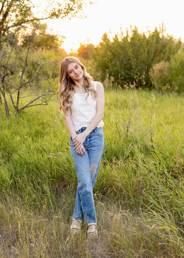 Close-up senior portrait of Liv Mitson with soft natural light in a field