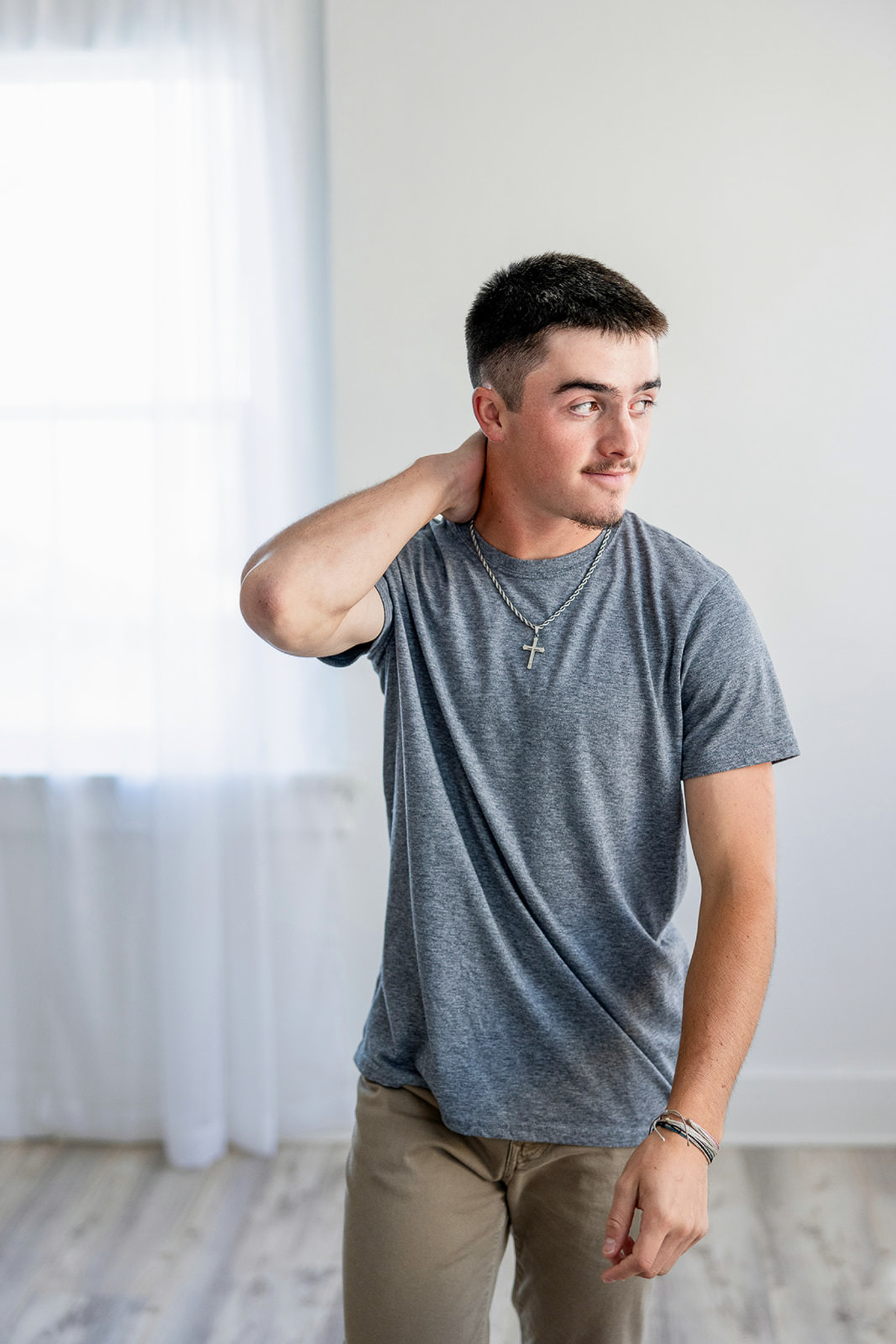 Senior boy in gray tshirt getting senior photos in a studio