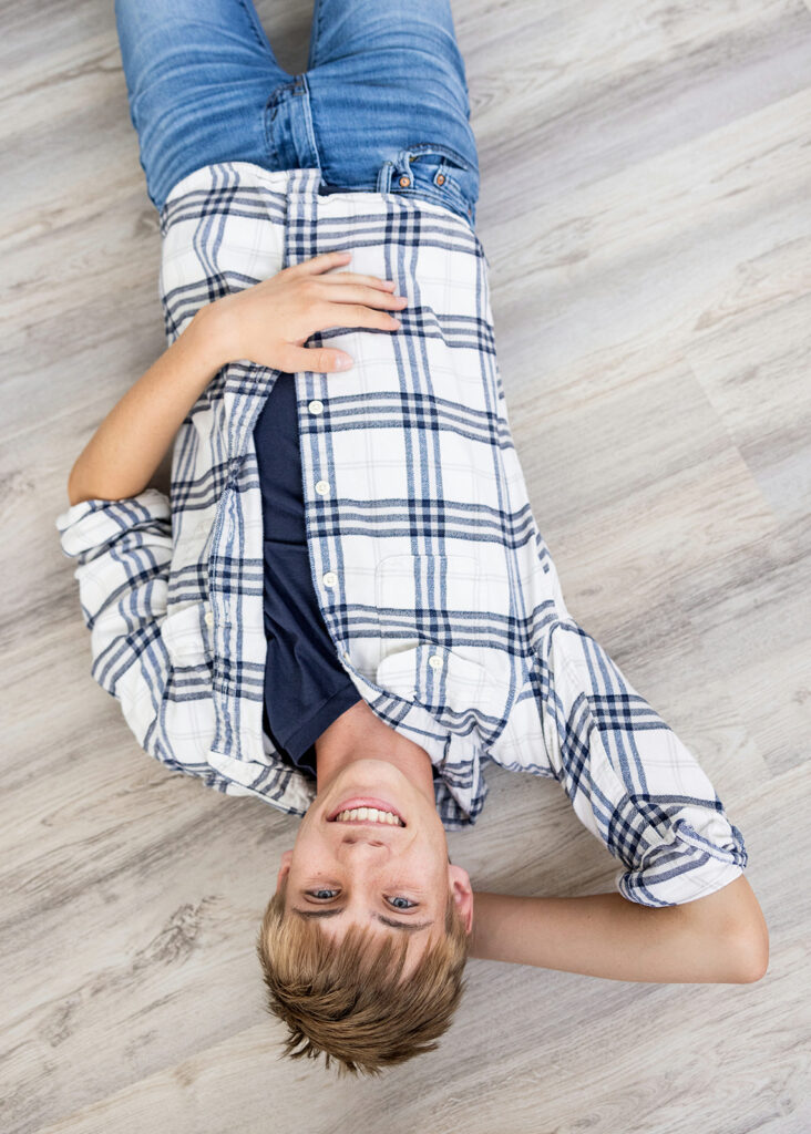 Grady standing in natural light in studio for senior portraits