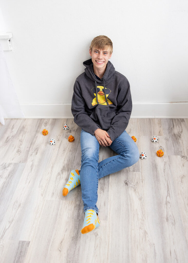 Grady sitting in natural light in a Williston ND studio for senior portraits