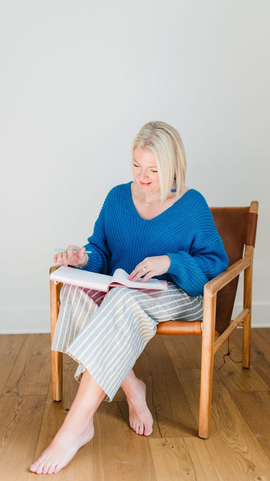 A relaxed mentor writing barefoot in a journal—offering heartfelt photography tips for beginners with ease.







