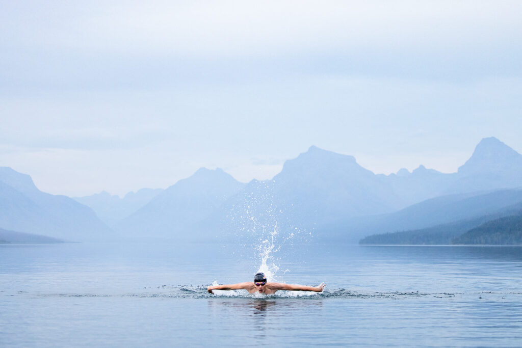 A swimmer breaks the stillness of a mountain lake—capturing bold, dynamic photography tips for beginners.







