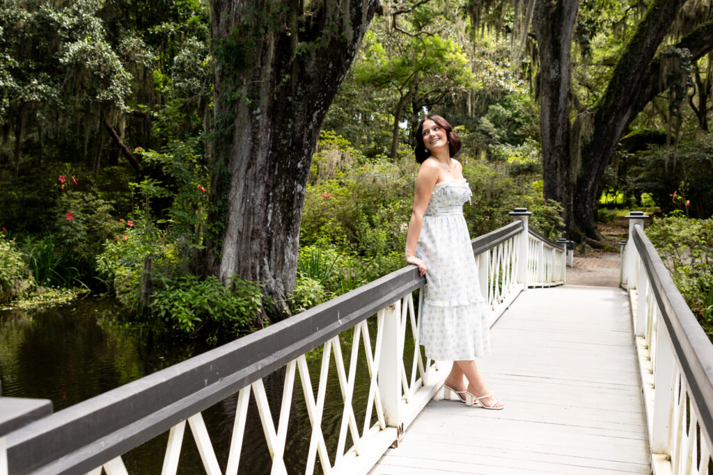 Senior standing on iconic Magnolia Plantation white bridge
