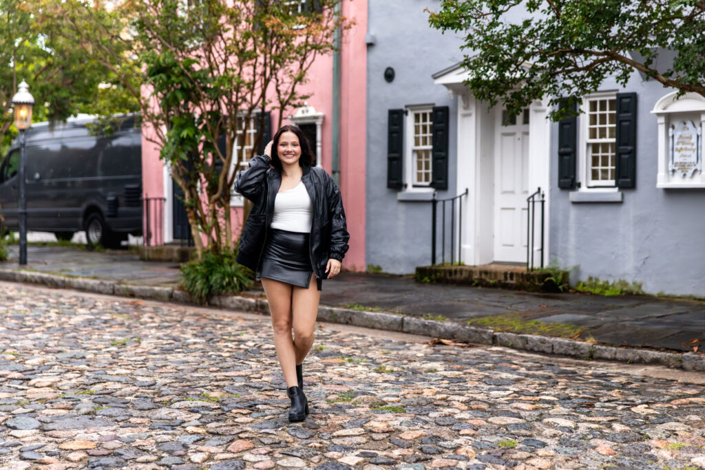 High school senior girl posing in front of pastel homes on Chalmers Street

