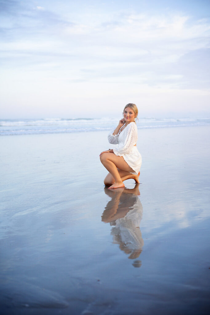 A high school senior girl poses next to the ocean during her Cape Coral Florida vacation senior session