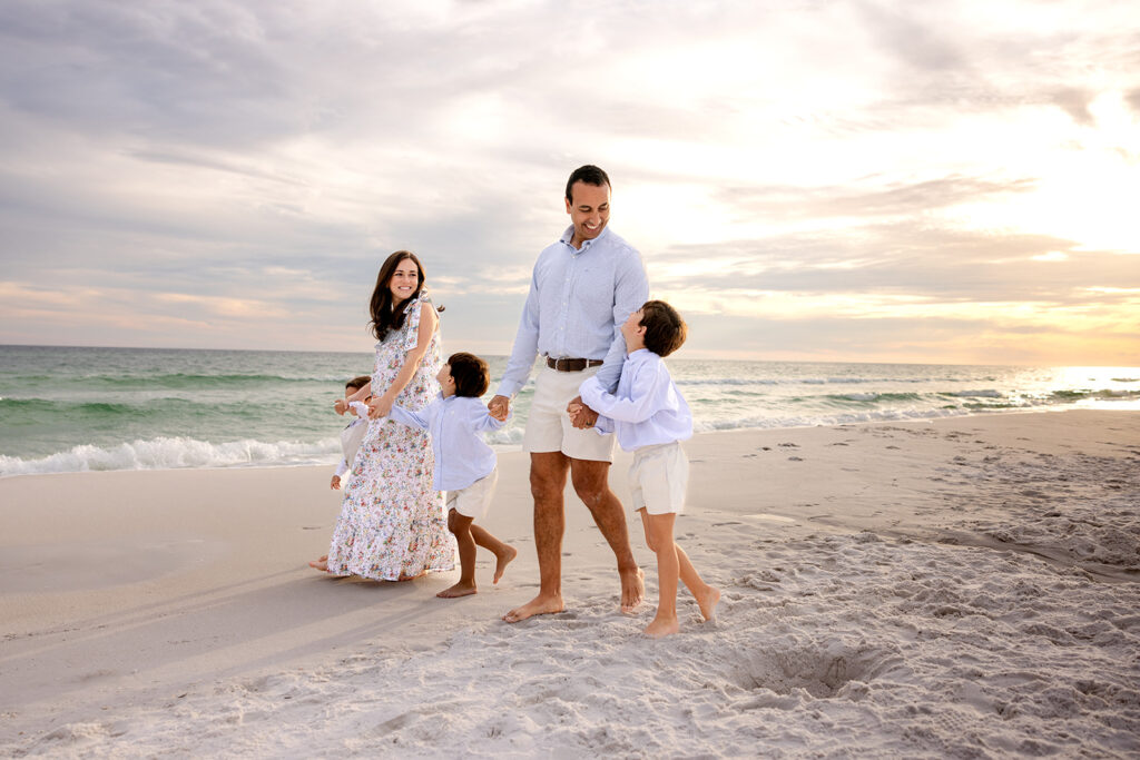 A family of five walk hand in hand along one of hte beaches near cape coral fl