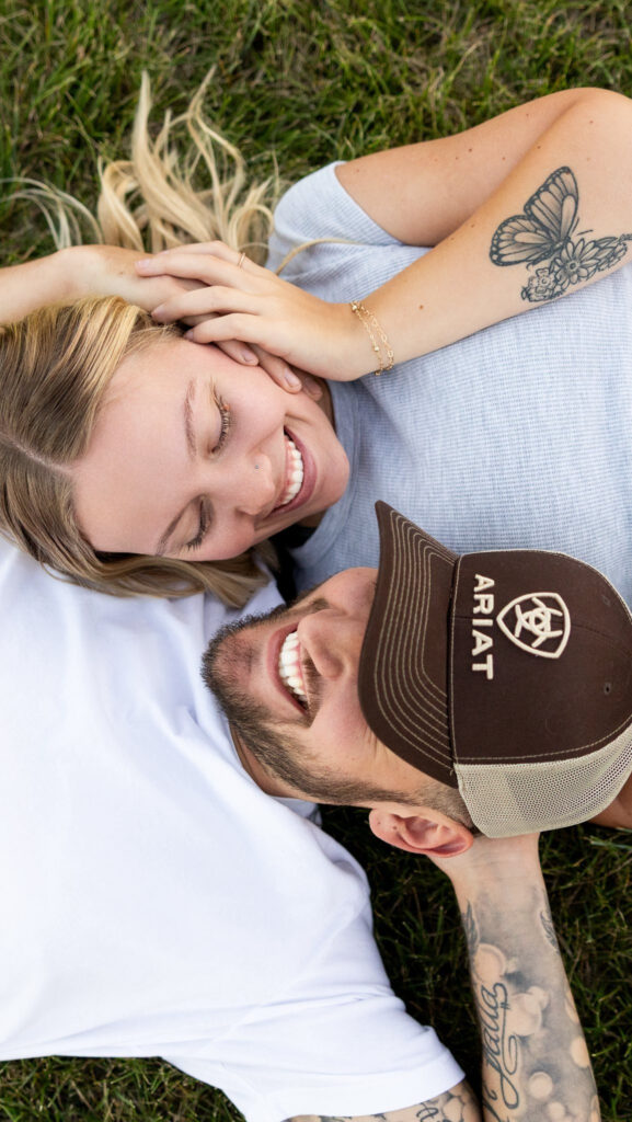 Smiling couple lying in the grass, sharing a quiet moment, reflecting the joy of slow business growth.
