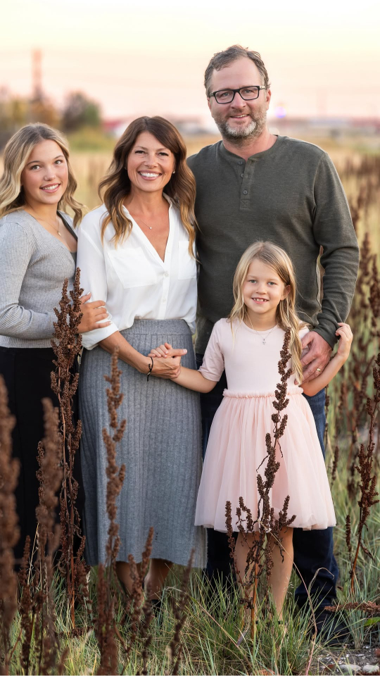 Family posing in fall field during golden hour, perfect inspiration for a travel session in the fall.
