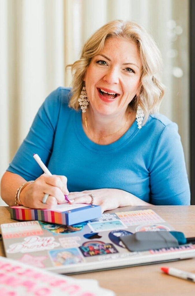 Woman writing in a travel planner, perfect for planning your travel calendar as a photographer.