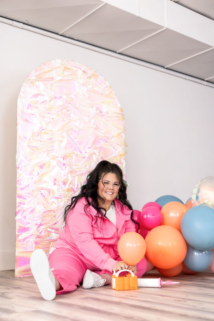 An event planner creates a balloon arch during a north dakota brand photography session 
