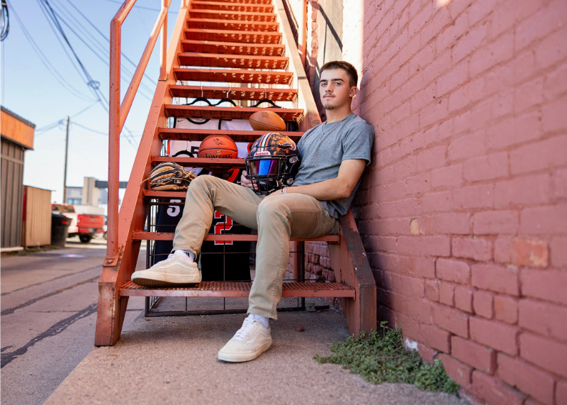 Senior guy sitting on outdoor stairs with sports gear, perfect for a travel session guide for clients.