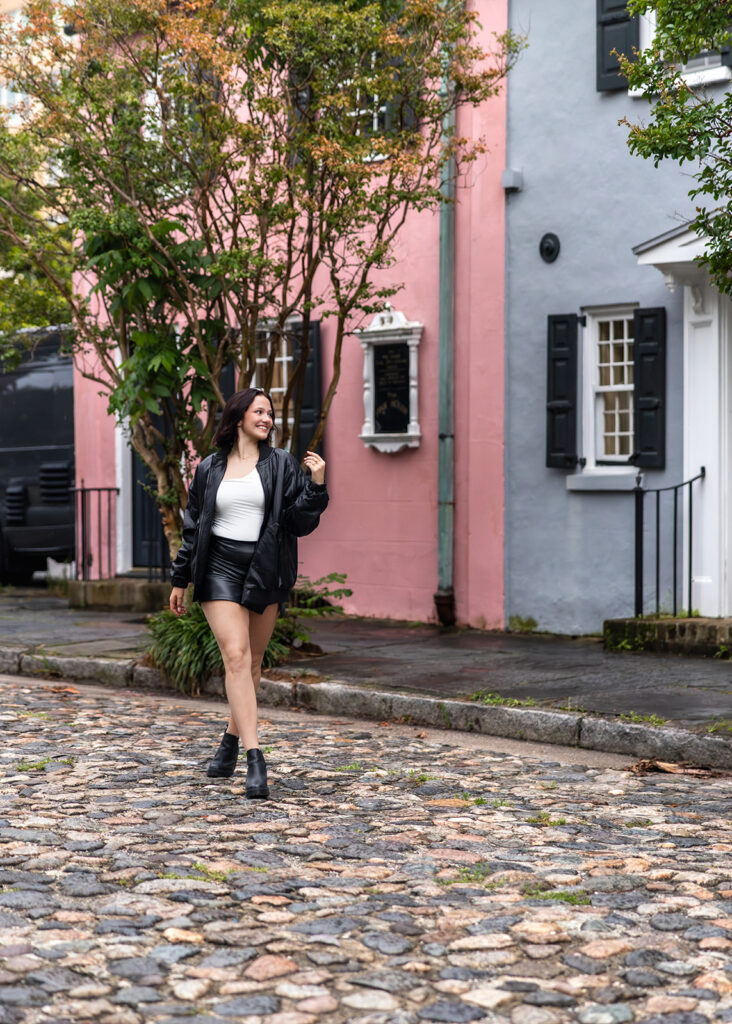 A young woman is photographed on Rainbow Row in a blog full of senior trip ideas 