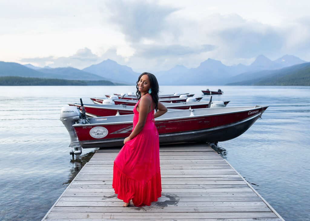 Senior in pink dress on dock at Lake McDonald