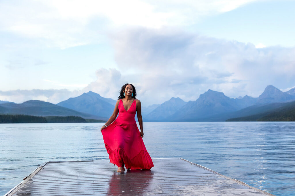 Senior in pink dress on dock at Lake McDonald