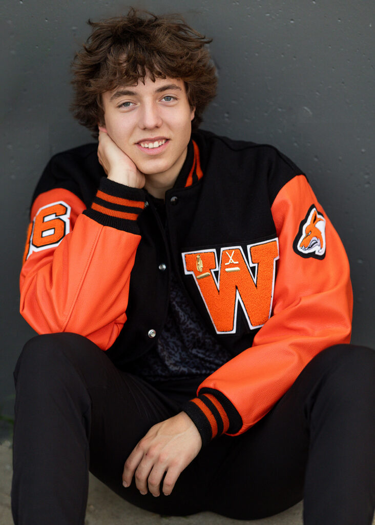 Trygve Zunich wearing his letterman jacket during his senior session outdoors