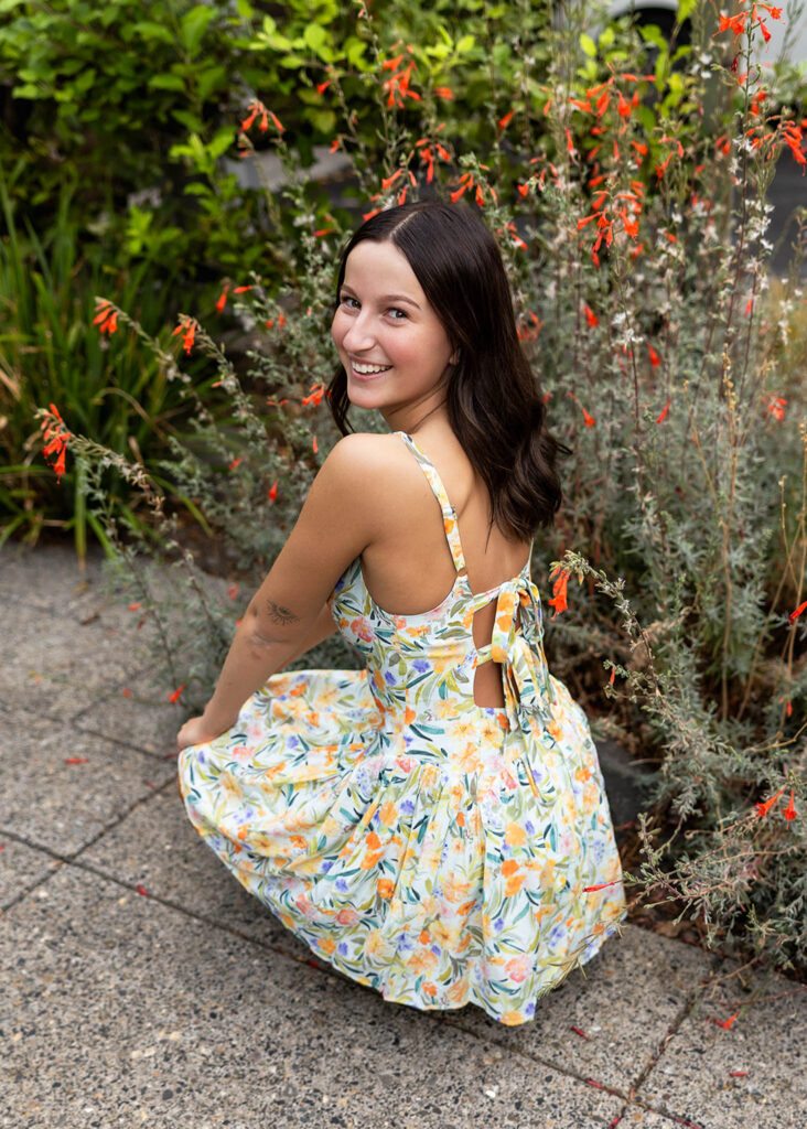 Senior girl squatting in the Pearl District in Portland, OR