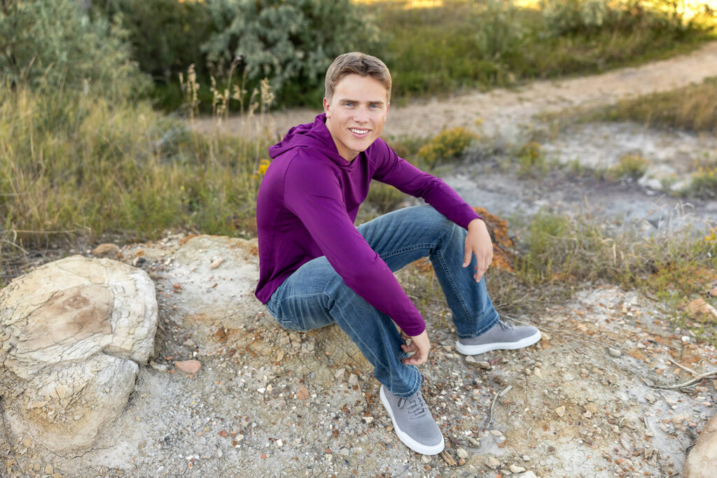 Senior boy siting on the butte at Lewis & Clark State Park